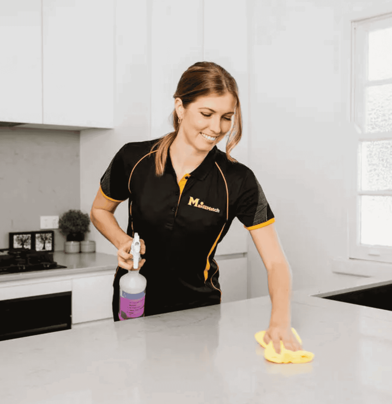 Maid2Match expert domestic cleaner wiping kitchen benchtop in a house clean