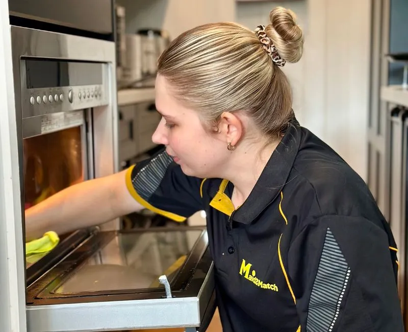 Maid2Match expert house cleaner cleaning a microwave oven