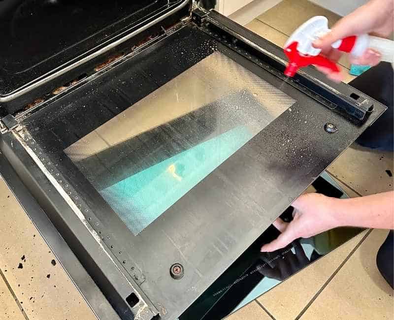 Maid2Match professional house cleaner cleans oven door during oven cleaning
